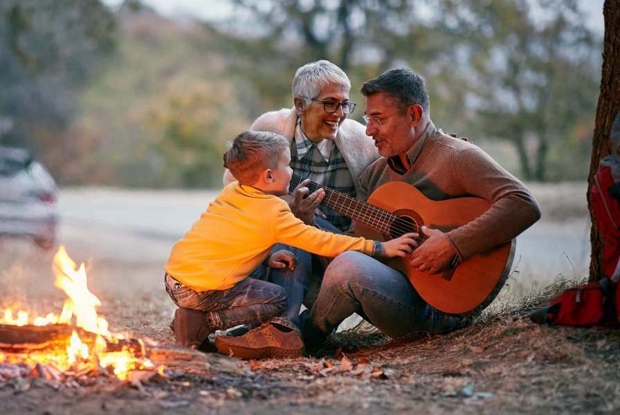 Intergenerational play campfire and guitar